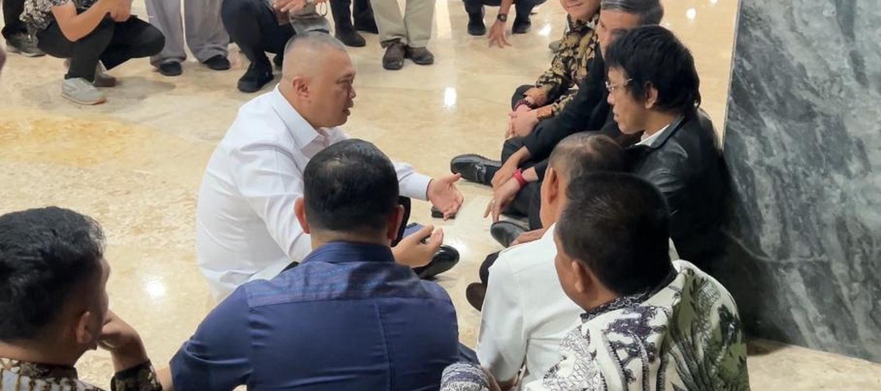 Menhub Dudy Purwagandhi dan anggota DPR RI duduk di lantai bahas terkait ojol. (NTVNews.id) 