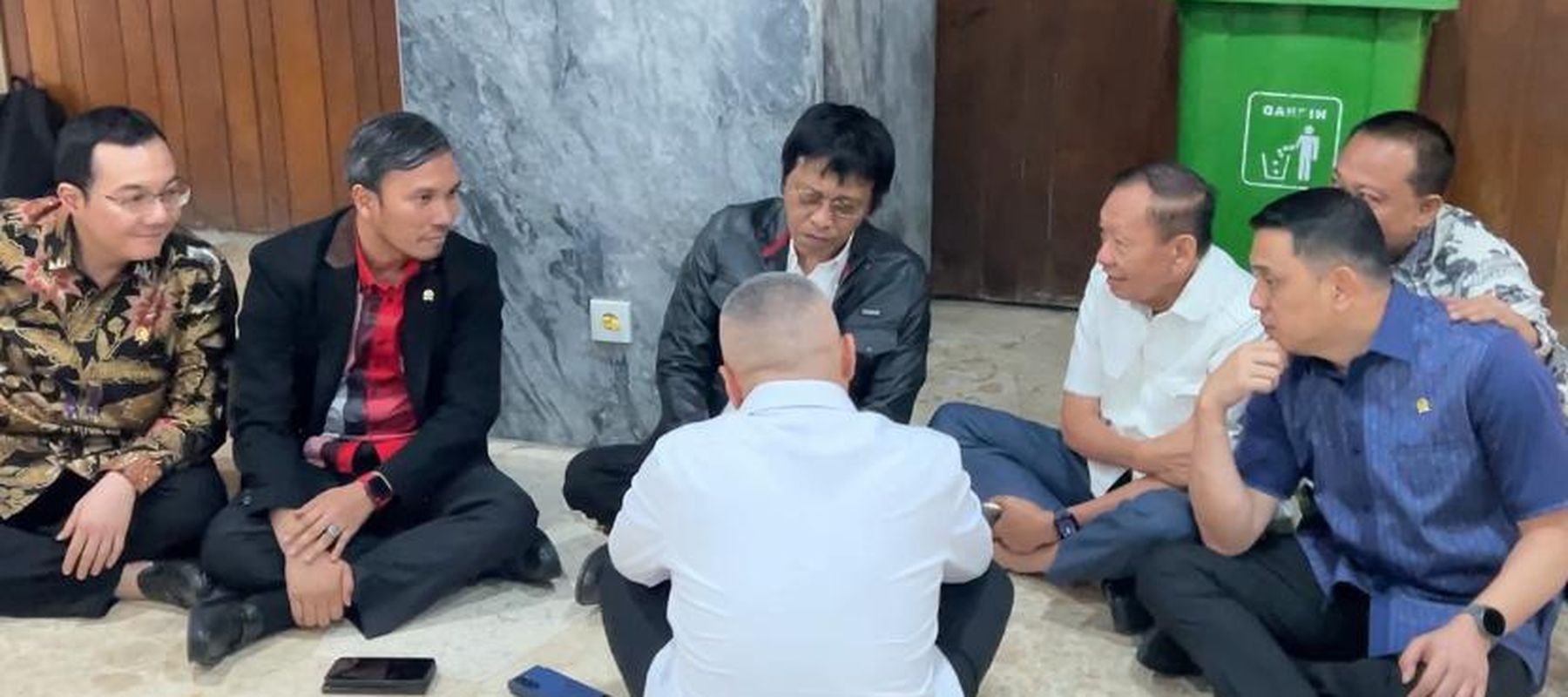 Menhub Dudy Purwagandhi dan anggota DPR duduk di lantai bahas nasib ojol. (NTVNews.id) 