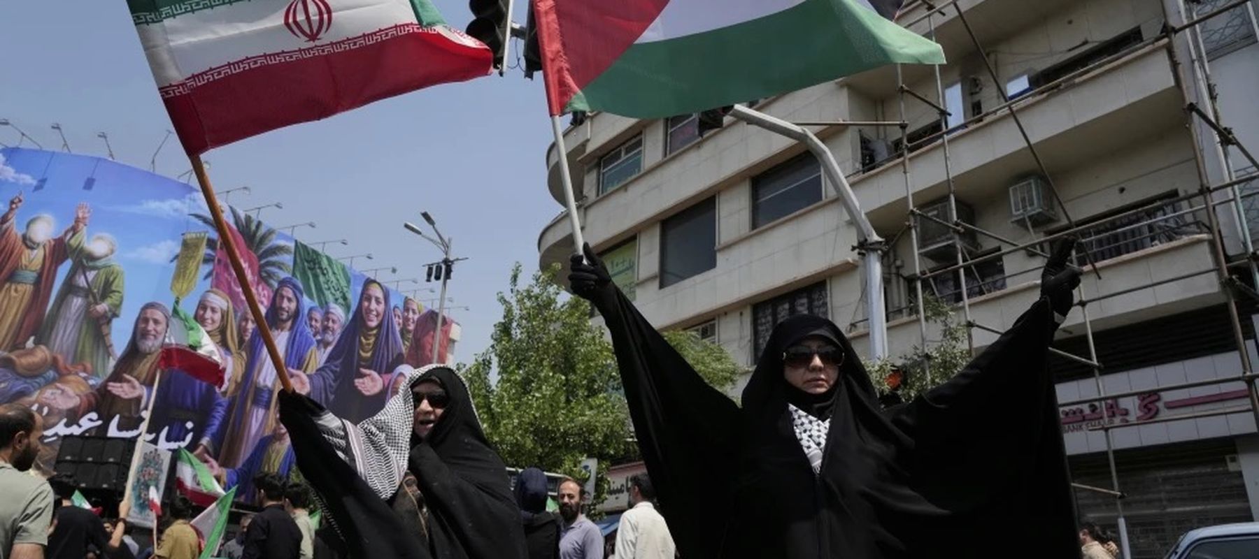 Pendemo Iran mengibarkan bendera Iran dan Palestina dalam aksi anti-Israel di Tehran.