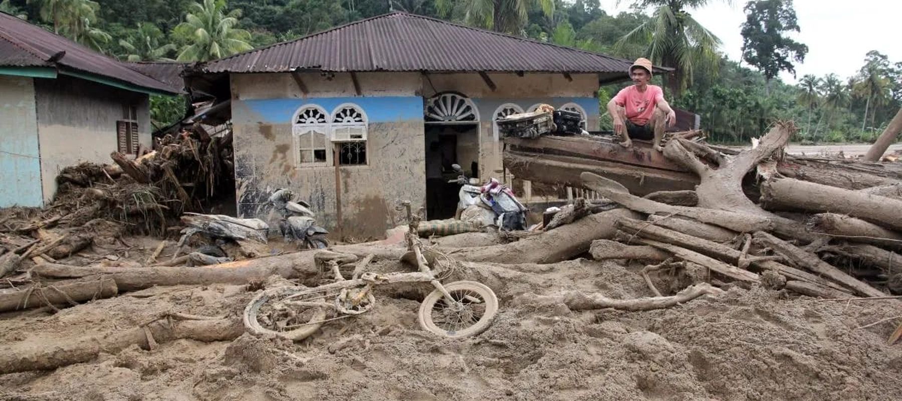 Warga berada di depan rumah yang rusak akibat banjir bandang di Kecamatan Silbolga, Kabupaten Tapanuli Selatan, Sumatera Utara, Jumat (28/11/2025). BPBD Tapanuli Selatan mencatat hingga Jumat (28/11/2025) sebayak 32 orang meninggal dunia di wilayahny