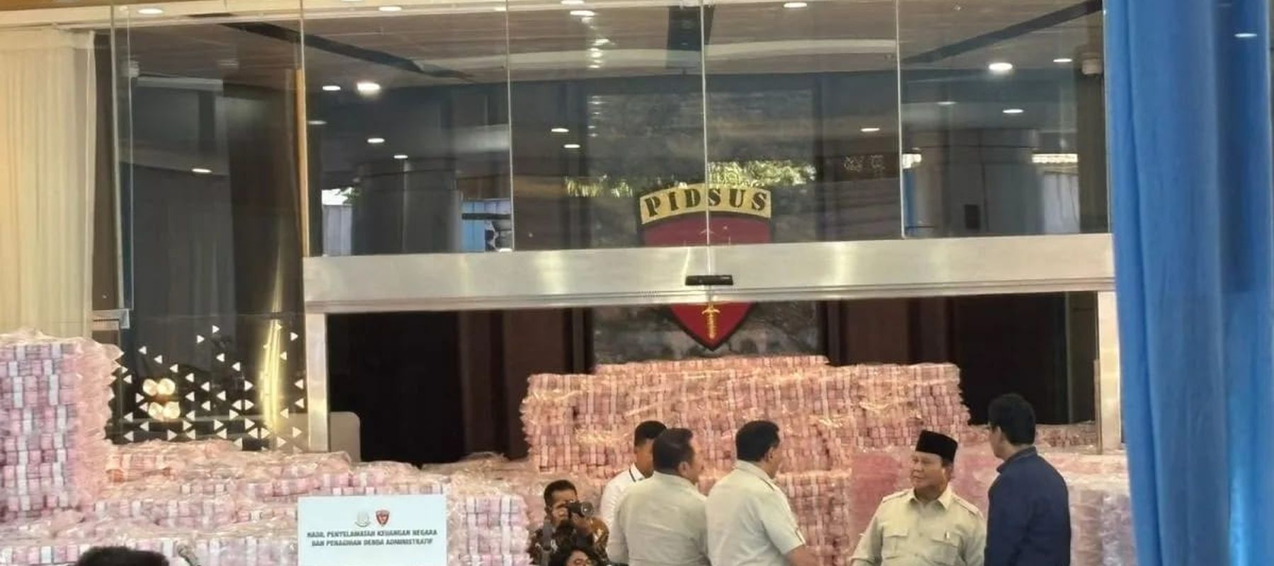 Presiden Prabowo Subianto berbincang dengan para menteri di depan tumpukan uang hasil denda administratif Satgas PKH dan penyelamatan keuangan negara di Gedung Bundar, Kejaksaan Agung, Jakarta, Rabu 24 Desember 2025. ANTARA/Mentari Dwi Gayati