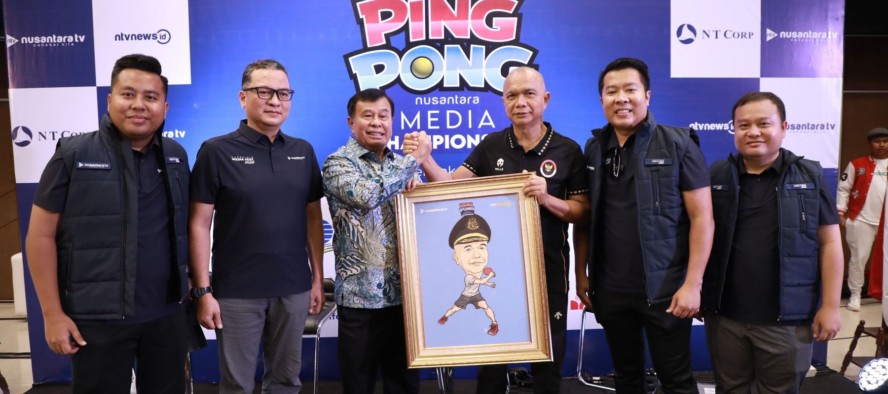 Presiden Komisaris NT Corp memberikan karikatur kepada JAMIntel Reda Manthovani di acara Nusantara Media Fest