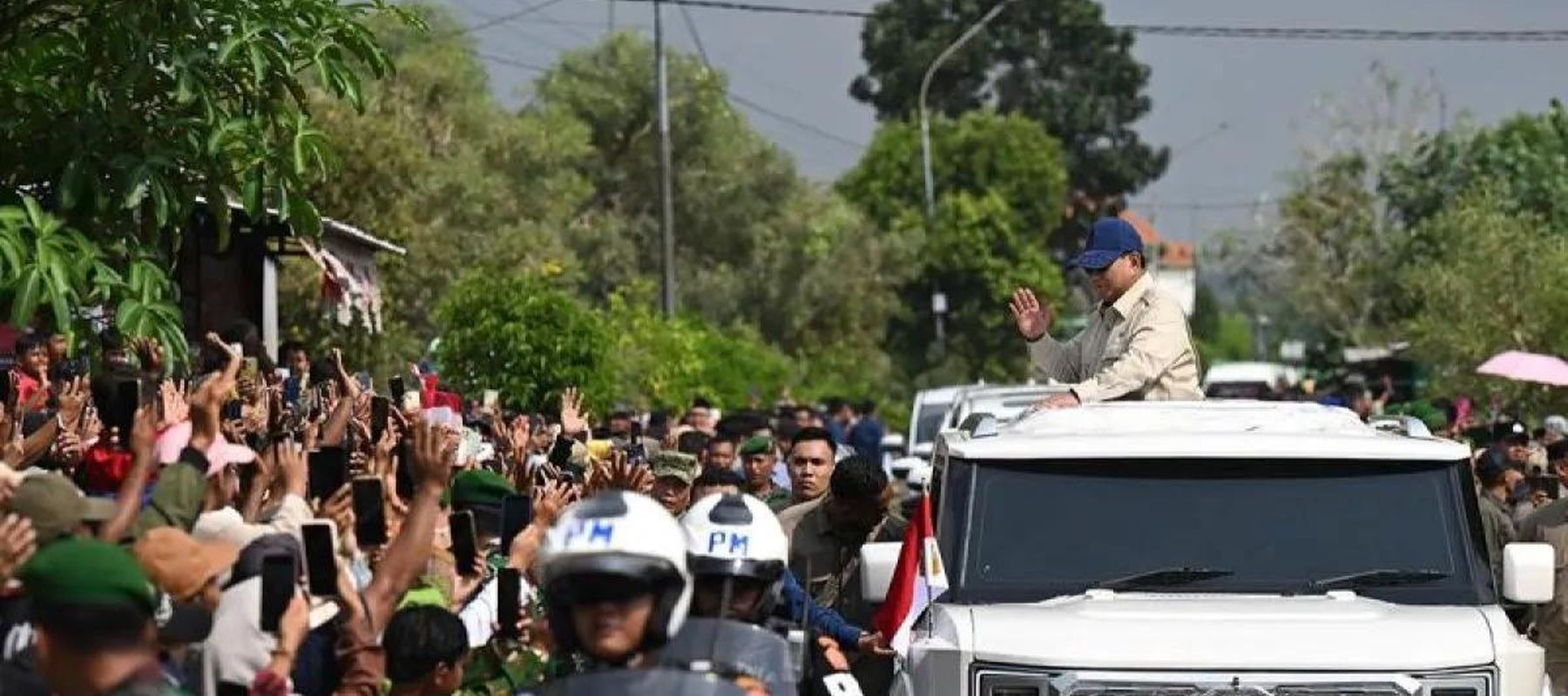 Presiden Prabowo Subianto (kanan) menyapa masyarakat dari atap mobil kepresidenan Maung Garuda saat tiba di lokasi acara peluncuran 1.061 gerai Koperasi Desa/Kelurahan Merah Putih (KDKMP) di Kabupaten Nganjuk, Jawa Timur, Sabtu 16 Mei 2026. ANTARA/HO