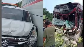 Mobil Ertiga kegencet di samping Bus Primajasa.