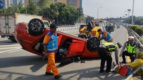 Sebuah mobil terbalik di ruas Tol Dalam Kota KM 12+800 (titik kenal sebelum layang flyover Tomang) arah Grogol Jakbar, pada hari Rabu, 17 Juli 2024.