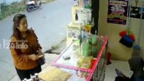 Wanita muda tersebut santai mengambil uang milik gerai Pulsa