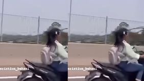 Wanita tersebut santai masuk tol dengan motornya.