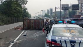 Truk pengangkut makanan kucing terguling di Tol Dalam Kota, mengganggu arus lalu lintas menuju Bandara Soekarno-Hatta.