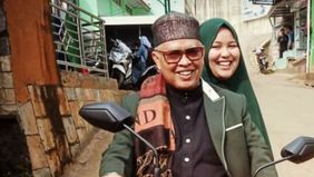 Abah Aos memboncengi istrinya naik motor.