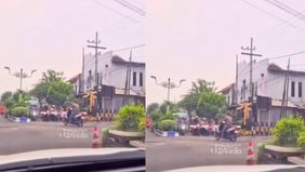 Aksi nekad pria ini terekam kamera pengendara mobil yang berhenti di perlintasan. Dalam video, seorang warga berupaya menarik pria tersebut dari tengah rel. Namun, warga tak berani lantaran Kereta Api akan melintas.