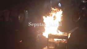 Terlihat beberapa orang peserta pawai obor banyak berhamburan yang mereka tumpangi itu dikarenakan alat gensetnya terbakar posisi berada di dalam mobil pickup.