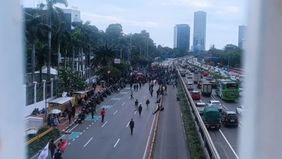 Petugas menutup sementara Jalan Gatot Subroto arah Grogol, Jakarta Barat, pada Kamis, 20 Maret 202 yang diakibat demonstrasi penolakan RUU TNI yang diadakan oleh elemen mahasiswa dan aliansi masyarakat.