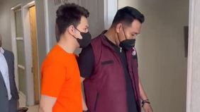 Jonathan Frizzy terlihat menggunakan baju oranye dan sarung saat diperiksa oleh polisi di Polresta Bandara Soekarno-Hatta.