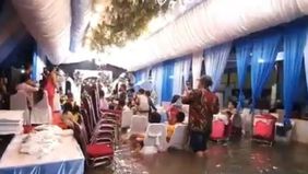 Meski banjir rob merendam kawasan pesisir Jakarta Utara, semangat warga RW 22 Muara Angke, Kelurahan Pluit, Penjaringan tak surut untuk menggelar resepsi pernikahan. Acara tetap berlangsung pada Senin, 23 Juni 2025 malam, meskipun air mencapai hampir
