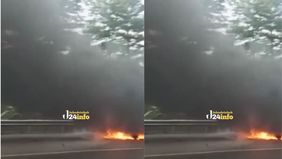 Sebuah mobil minibus berwarna putih terbakar hebat di kilometer 27 Tol Jakarta-Cikampek arah Cikampek, Selasa siang (5/8/2025). Kejadian tersebut sempat menggegerkan pengendara lain yang melintas di jalur padat tersebut.