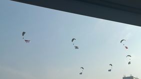 Sebanyak 80 prajurit Tentara Nasional Indonesia (TNI), termasuk pasukan elite Komando Pasukan Khusus (Kopassus) TNI Angkatan Darat, melakukan aksi terjun payung spektakuler sambil membawa anjing terlatih di kawasan Monumen Nasional (Monas), Jakarta, 