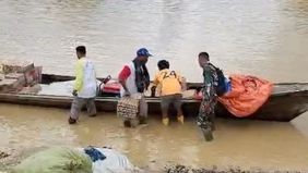 Deru mesin perahu motor memecah sunyi sungai yang meluap di Aceh Tamiang. Di atas air keruh sisa banjir bandang, petugas TNI dan relawan duduk rapat menjaga keseimbangan bersama himpitan karung dan kardus bantuan di atas perahu.