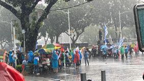 Hujan deras yang mengguyur kawasan Patung Kuda, Jakarta Pusat, tak memadamkan semangat ratusan buruh yang menggelar aksi demonstrasi menuntut keadilan upah. 
