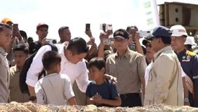 Sekretaris Kabinet Teddy Indra Wijaya tampak membagikan permen lolipop kepada anak-anak korban bencana saat mendampingi Presiden Prabowo Subianto meninjau jembatan Bailey atau jembatan sementara di Sungai Garoga, Kabupaten Tapanuli Selatan