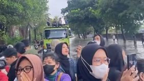 Sejumlah penumpang Transjakarta di Jalan Daan Mogot, Cengkareng, Jakarta Barat, terpaksa turun dari bus dan melanjutkan perjalanan menggunakan truk akibat kemacetan panjang yang dipicu banjir pada Kamis, 29 Januari 2026.
