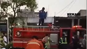 Api yang membara dengan cepat melahap bangunan-bangunan, membuat warga berusaha memadamkan api dengan alat seadanya.