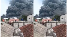 Kobaran api masih terlihat menyala di area gudang, disertai kepulan asap hitam pekat yang membubung tinggi ke udara.