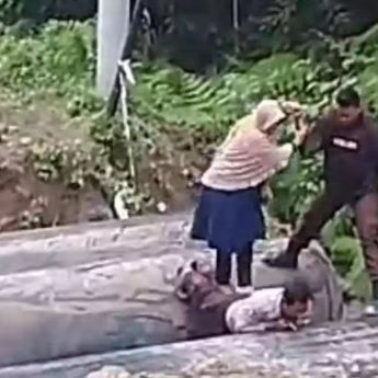 Jalan Terputus, Seorang Polisi Jadikan Punggungnya Jembatan untuk Ibu dan Anak Melintas