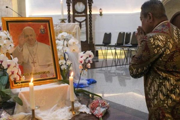 Umat Katolik berdoa di dekat foto Paus Fransiskus usai Misa Requiem di Gereja Katedral, Medan, Sumatera Utara, Jumat (25/4/2025). 