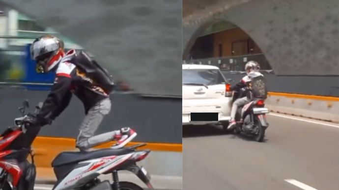 Seorang pengendara motor melakukan atraksi freestyle di tengah jalan raya