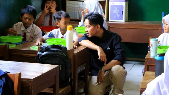 Wakil Presiden terpilih Gibran Rakabuming Raka berbincang dengan seorang siswa saat melakukan pemantauan program makan bergizi gratis di SDN 4 Tangerang, Senin (5/8/2024)