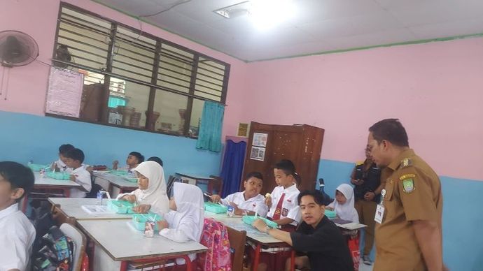 Wakil Presiden terpilih Gibran Rakabuming Raka didampingi Penjabat Wali Kota Nurdin memantau uji coba makan bergizi gratis di SDN 4 Tangerang, Senin (5/8/2024)