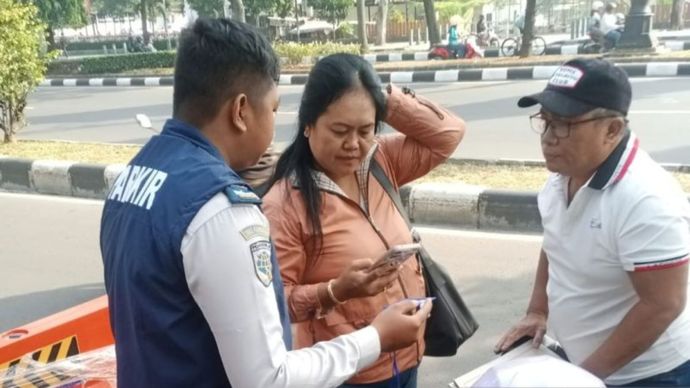 Pengendara membayar parkir melalui QR Code di Jalan Tegar Beriman, Cibinong, Kabupaten Bogor, Jawa Barat.