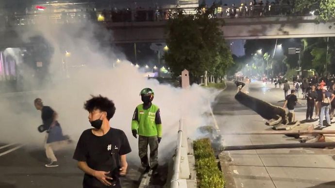 Polisi menembakkan sejumlah peluru gas air mata sebelum membubarkan massa dengan pasukan bermotor. 