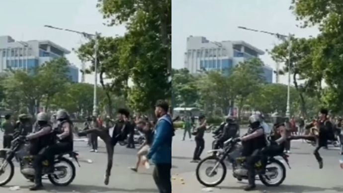 Seorang pendemo menendang anggota polisi.