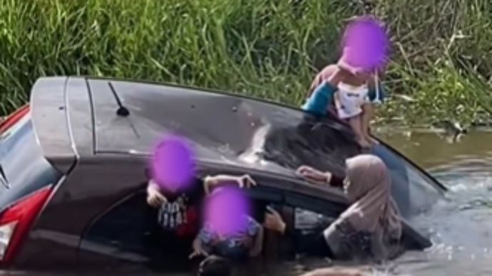 sebuah mobil yang dikendarai oleh seorang ibu secara tidak sengaja menabrak tiang listrik dan kemudian masuk ke sungai.