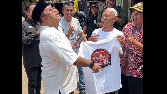 Bakal calon wakil gubernur Jakarta Rano Karno saat menerima kaos untuk kampanye dari pendukungnya. 