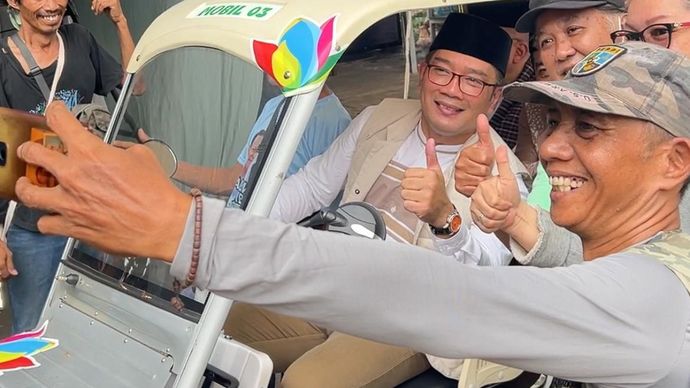 Bakal calon gubernur Jakarta Ridwan Kamil saat berswafoto dengan warga di Setu Babakan, Jakarta Selatan. 