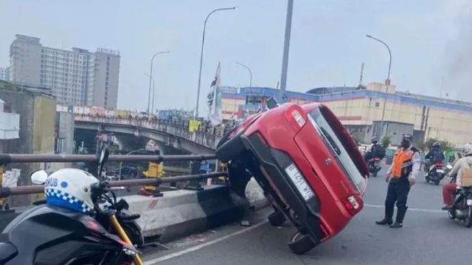 Mobil nyangkut di pembatas flyover