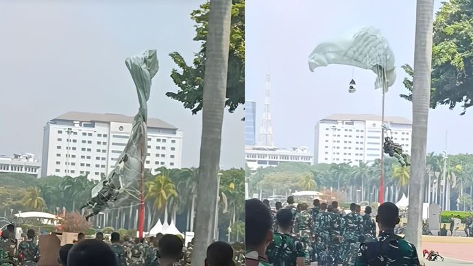 Seorang penerjun payung TNI terpaksa nyangkut di tiang lampu akibat hembusan angin kencang di Monas.