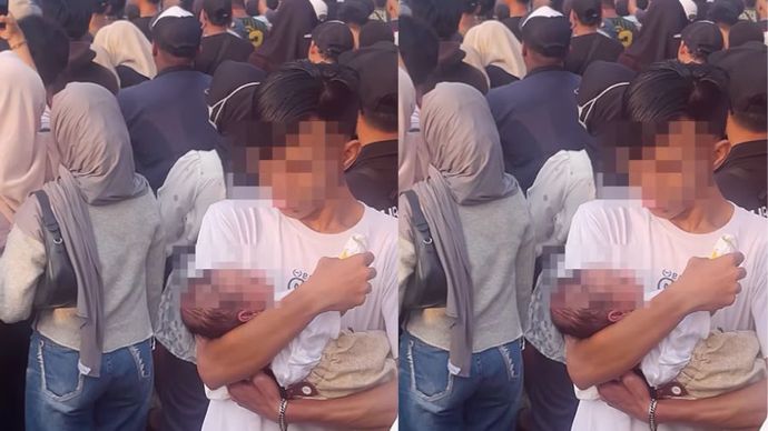 Seorang pria membawa bayi yang diduga baru lahir di tengah kerumunan konser musik.