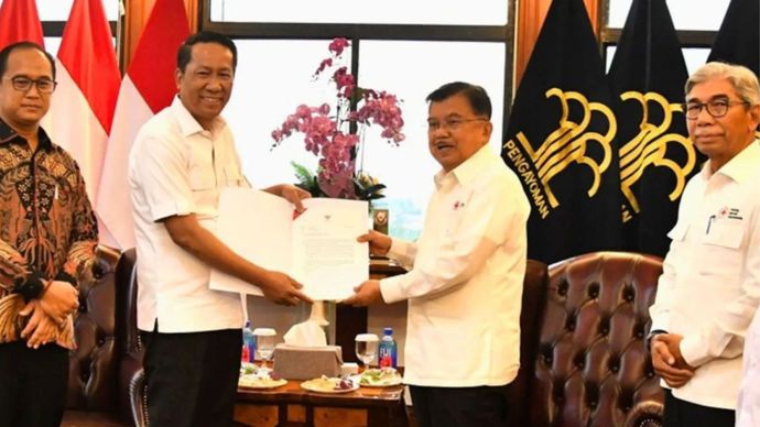 Menteri Hukum (Menkum) Supratman Andi Agtas (kiri) menyerahkan surat keputusan terkait kepengurusan baru PMI kepada Ketua Umum PMI Jusuf Kalla (kanan) di Kantor Kemenkum, Jakarta,