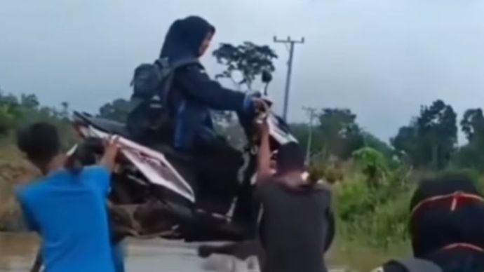 Warga angkat motor milik guru saat jalan kena banjir