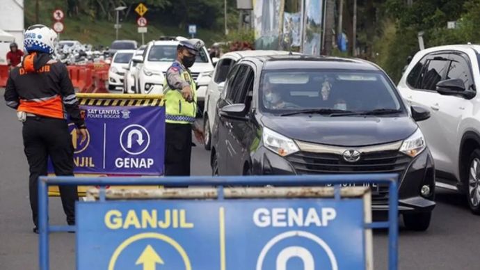 Petugas Sat Lantas Polres Bogor dan petugas Dishub Kabupaten Bogor mengarahkan kendaraan saat penyekatan kendaraan nomor polisi ganjil genap di jalur Puncak, Gadog, Kabupaten Bogor, Jawa Barat,