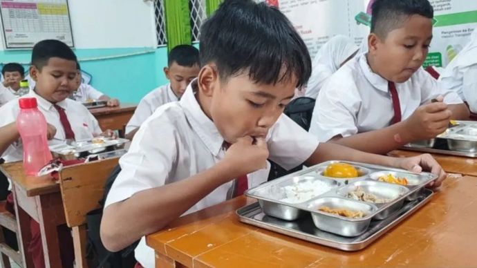 Sejumlah siswa tengah menyantap makanan yang telah disediakan dalam Program Makan Bergizi Gratis (MBG) di SDN 07 Pulogebang, Cakung, Jakarta Timur, Senin 6 Januari 2025.