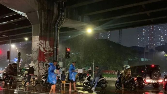 Sejumlah pengendara roda dua berteduh di bawah jalan tol yang berada di Jakarta Timur saat hujan deras terjadi pada Rabu (8/1/2025) malam.