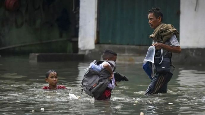 Warga melintasi banjir rob di Muara Angke, Jakarta, Senin (13/1/2025). BPBD DKI Jakarta mengimbau warga pesisir utara Jakarta untuk waspada terhadap potensi banjir rob hingga 17 Januari 2025 akibat pasang maksimum air laut yang bertepatan dengan fase Bulan Purnama.