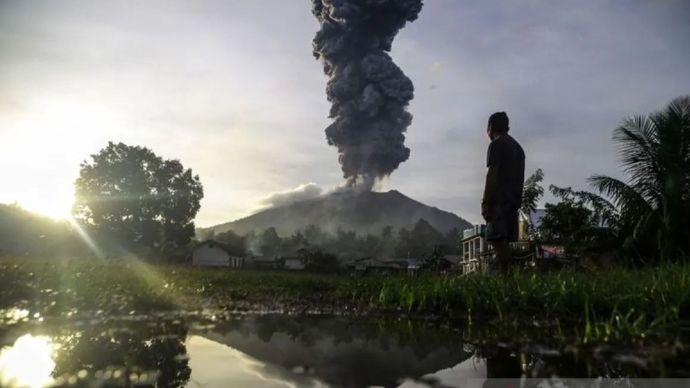 Seorang warga melihat erupsi dari kawah Gunung Ibu terlihat dari Desa Duono, Kabupaten Halmahera Barat, Maluku Utara, Rabu (15/1/2024).