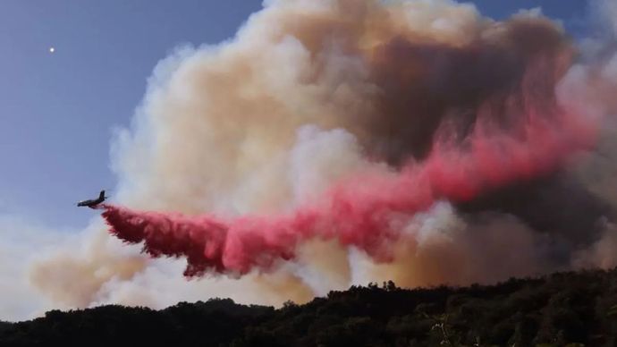 Sebuah pesawat pemadam kebakaran menjatuhkan bahan kimia untuk mencegah kebakaran hutan menyebar lebih jauh di perbukitan Mandeville Canyon di Los Angeles, California, Amerika Serikat, pada 11 Januari 2025. 