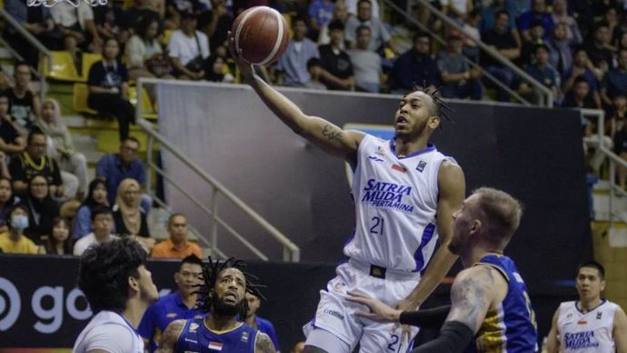 Pebasket Satria Muda Pertamina Jakarta Randy Bell (kedua kanan) melakukan lay up melewati adangan pebasket Prawira Harum Bandung Norbertas Giga (kanan) pada pertandingan pembuka Indonesia Basketball League (IBL) 2025 di C-Tra Prawira Arena, Bandung, Jawa Barat,