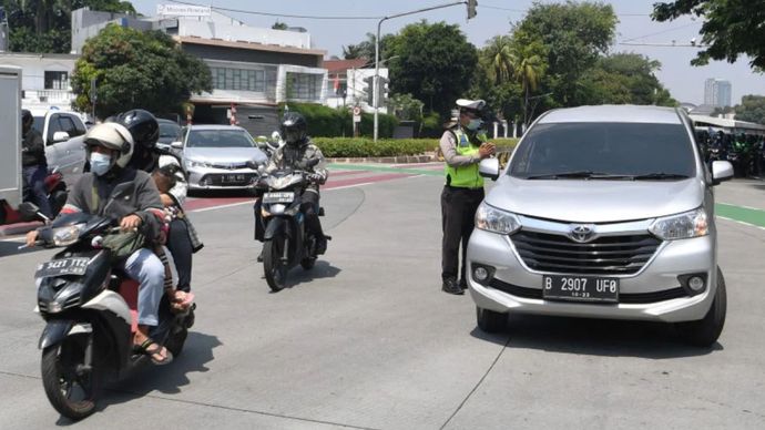 Arsip foto - Petugas Kepolisian melarang pengendara mobil berpelat nomor ganjil memasuki Jalan Sudirman di kawasan Bundaran Senayan, Jakarta, Kamis (12/8/2021). 